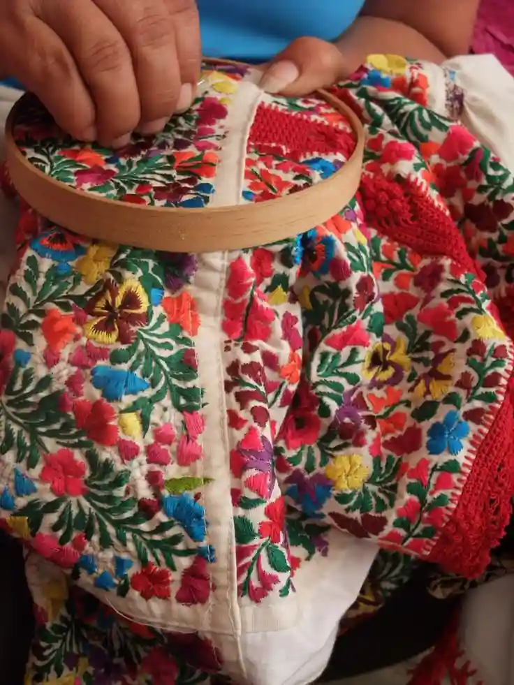 Artesano bordando huipil tradicional