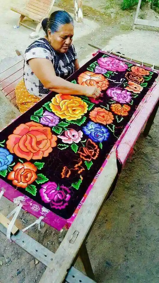 Artesana bordando a mano traje regional