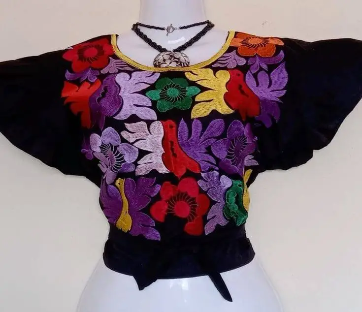 Blusa negra con bordado floral multicolor y cuello blanco