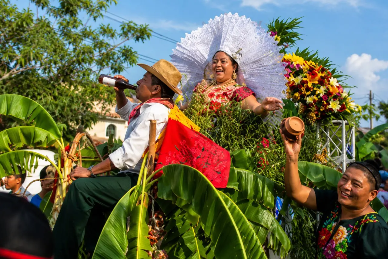 Mujer en celebración al aire libre con abanico blanco y flores